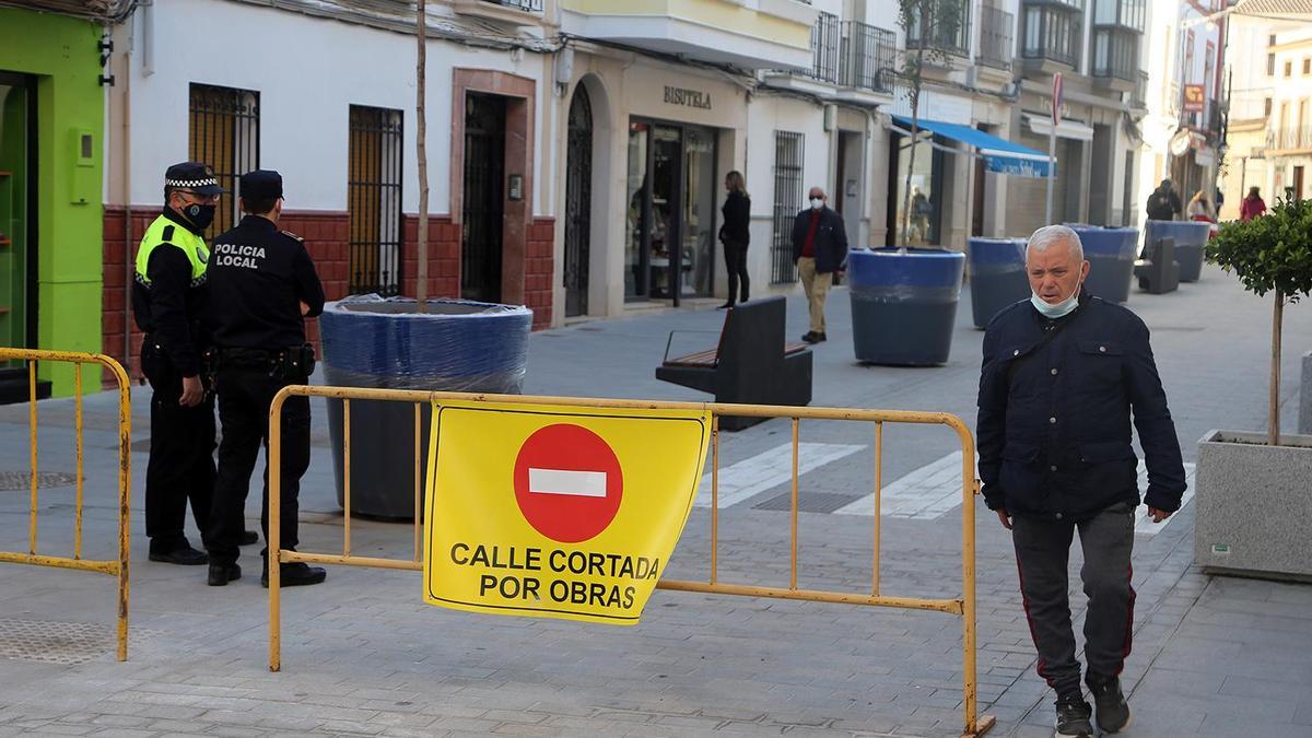Dos agentes de la Policía Local vigilan el acceso al nuevo tramo de la calle Puerta de Aguilar.