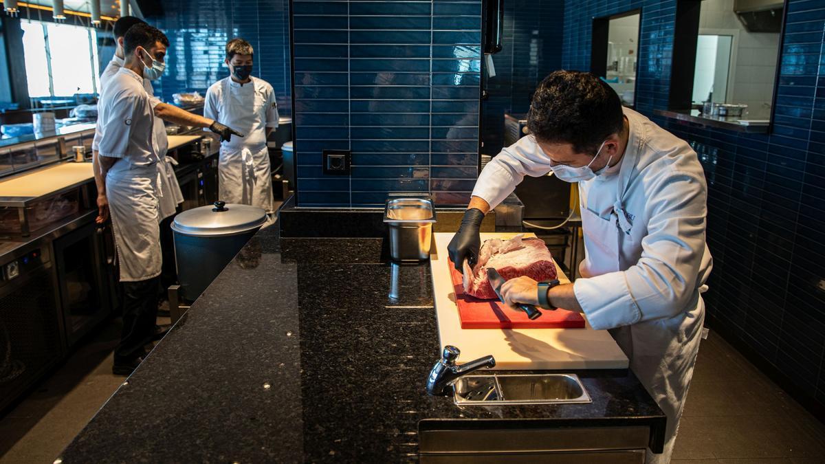 Personal de cocina prepara una pieza de carne de wagyu en el restaurante del hotel.