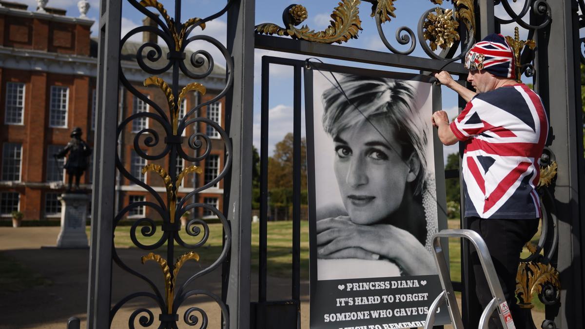 Un fan de Diana, John Loughrey, cuelga un cartel de la princesa en la puerta del Palacio de Kensington en Londres, Gran Bretaña, este viernes.