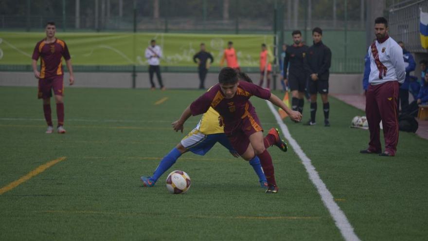 Un jugador del combinado regional cadete trata de marcharse de un rival