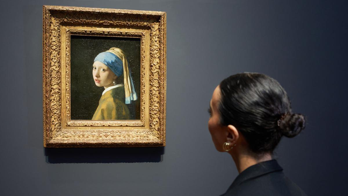 Una mujer observa 'La joven de la perla'.