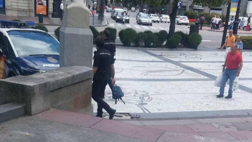 Agentes de la Policía Nacional retirando la mochila, ayer al mediodía, del Campo San Francisco.