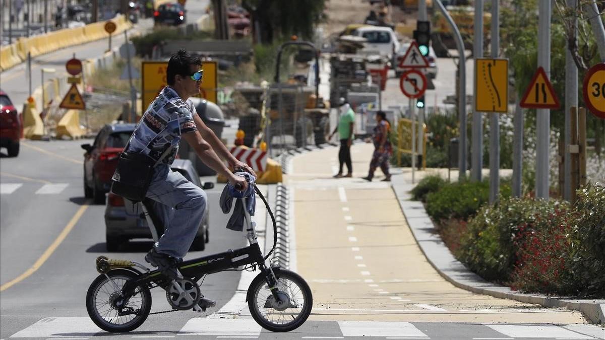 Un hombre circula con su bicicleta por el nuevo carril bici de la avenida de Salzareda, en Santa Coloma de Gramenet.