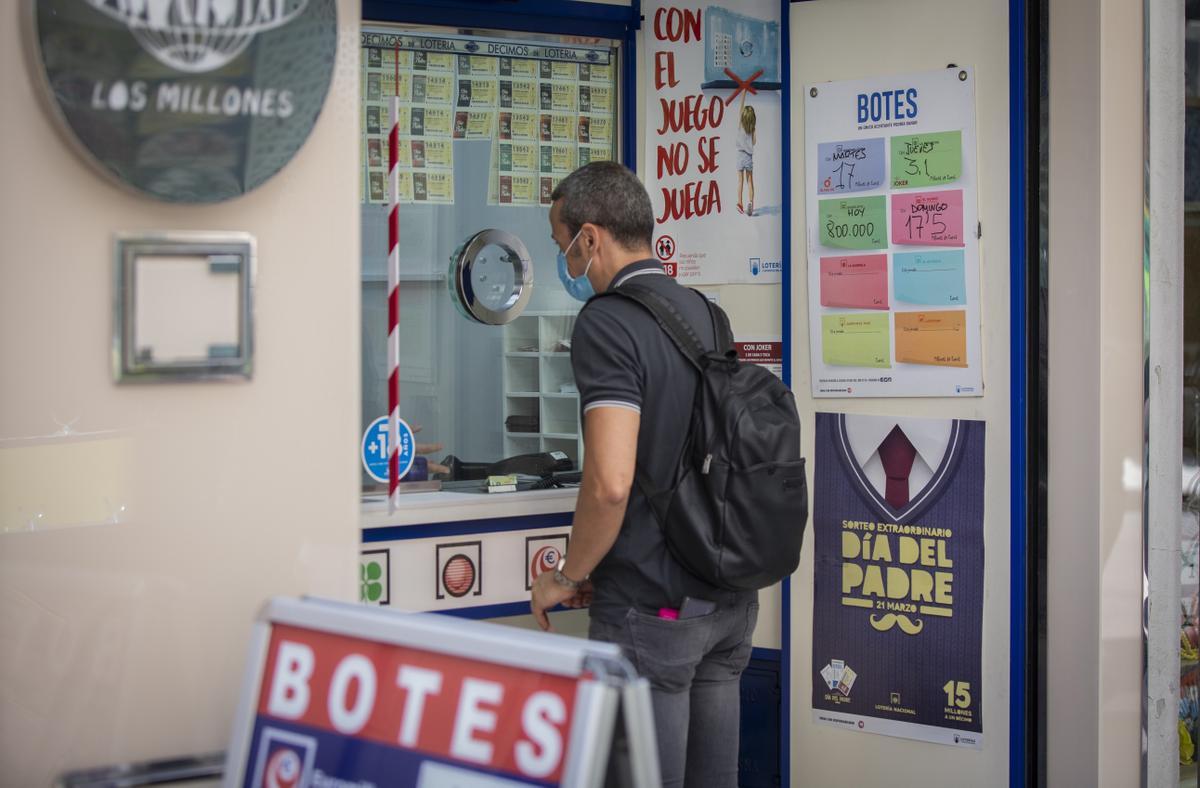 Archivo - Una persona compra un boleto de Euromillones en una Administración de Loterías, en una foto de archivo.