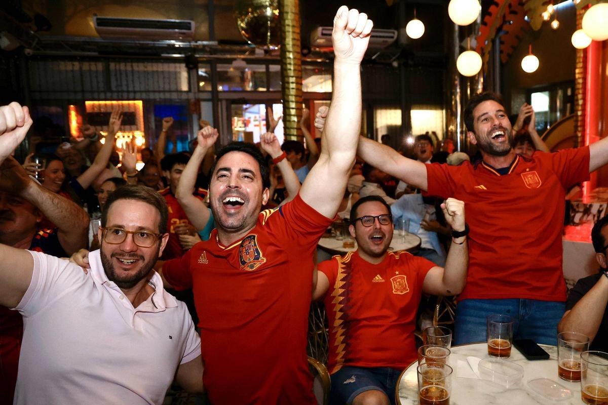 Un grupo de aficionados celebran una jugada de España.