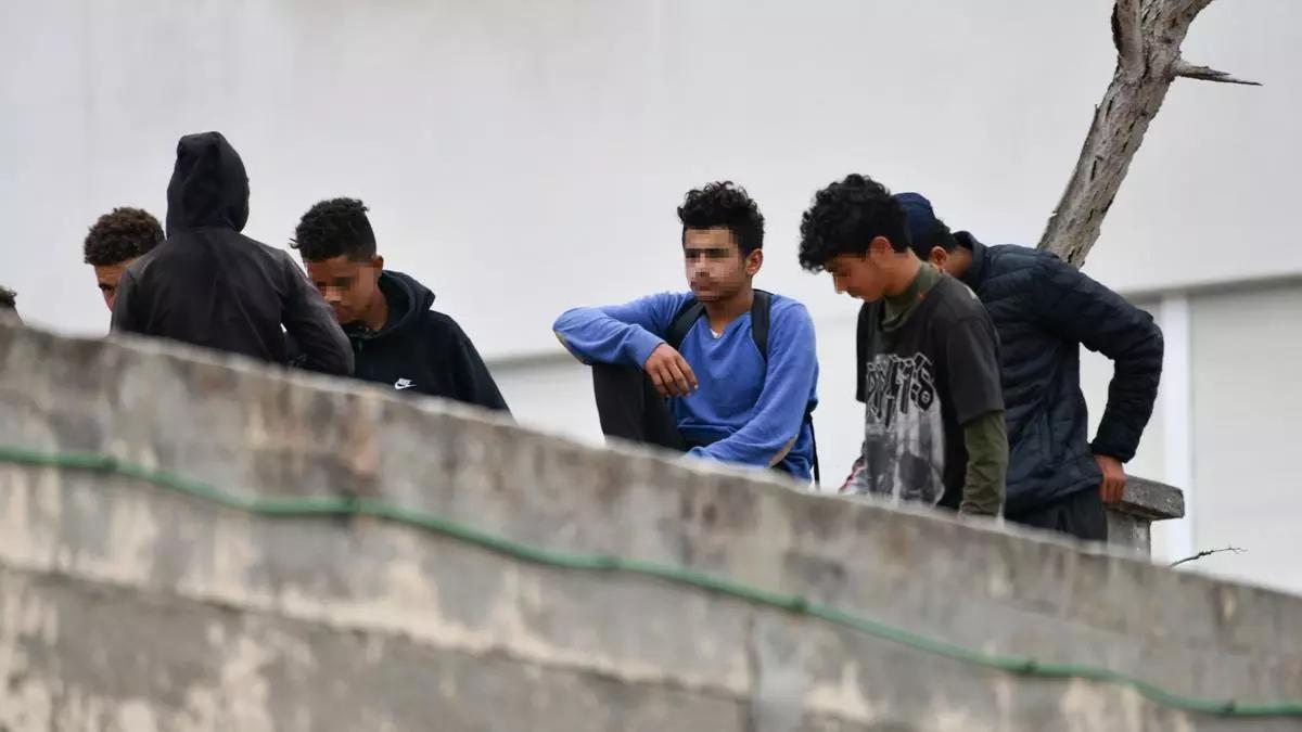 Varios menores migrantes, en el tejado de una nave industrial, en Ceuta.