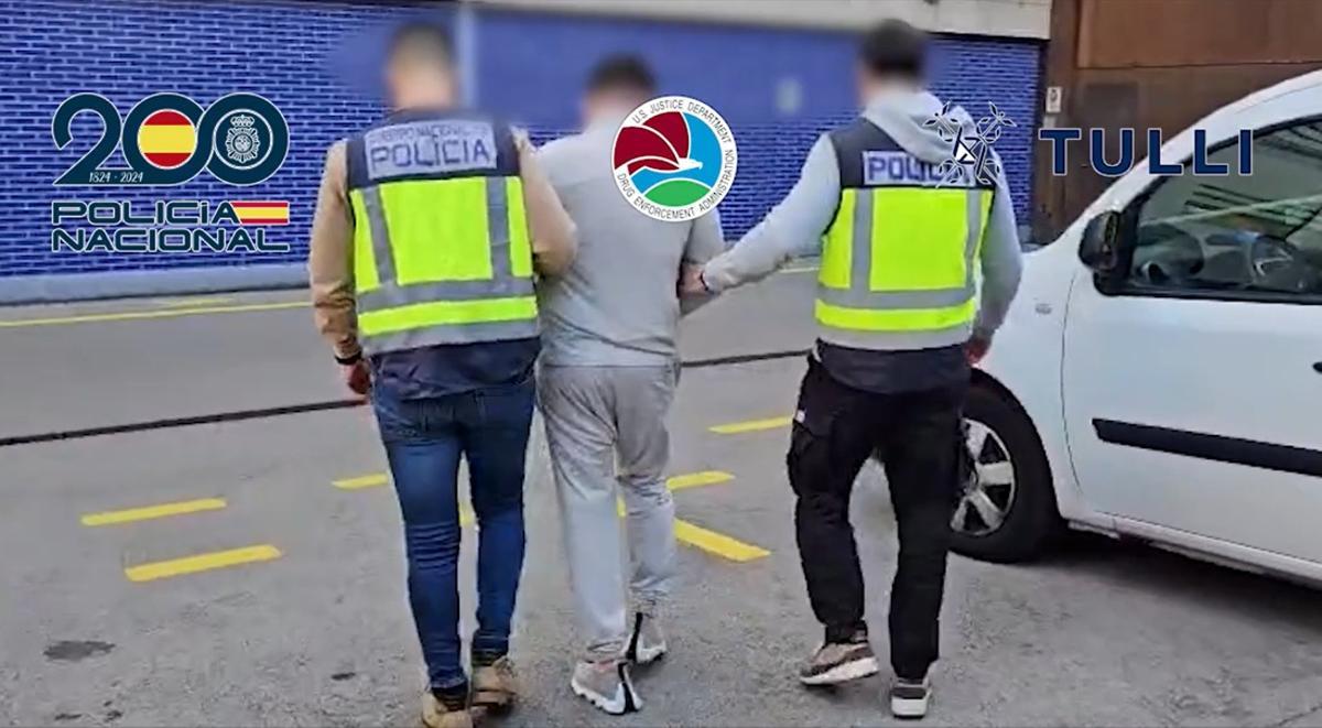 La Policía con uno de los apresados.