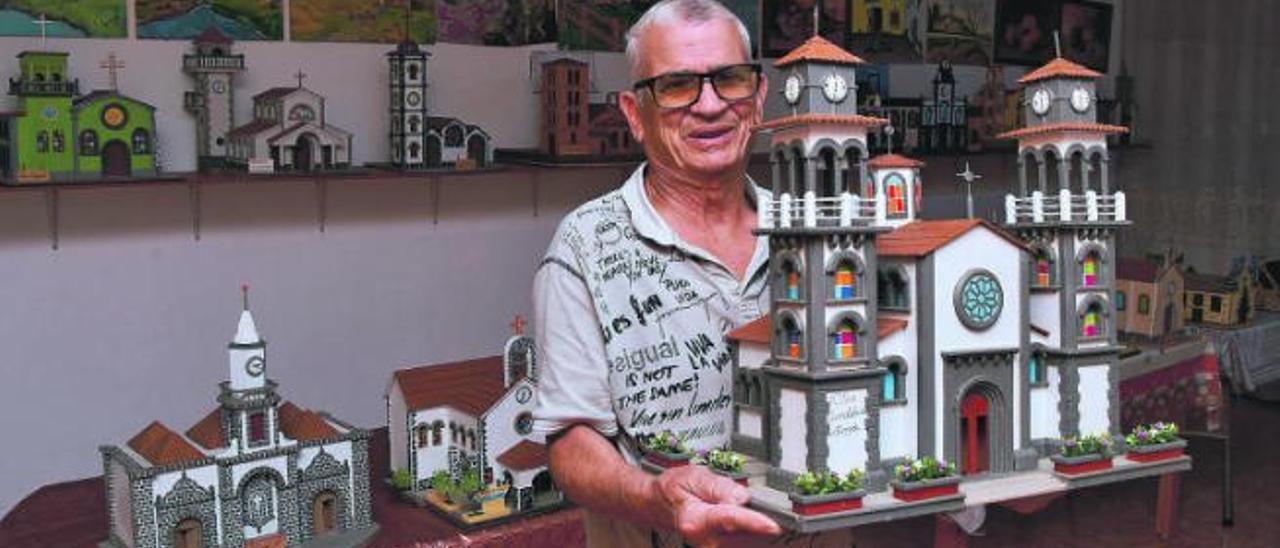 Manuel Santana Caballero, en su vivienda con la maqueta de la iglesia de Moya, delante de una parte de las maquetas y pinturas que ha realizado.