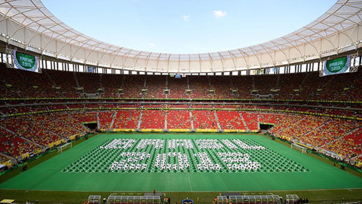 Figurantes de la ceremonia de inauguración forman el lema Brasil 2013 en el Estadio Nacional de Brasilia.