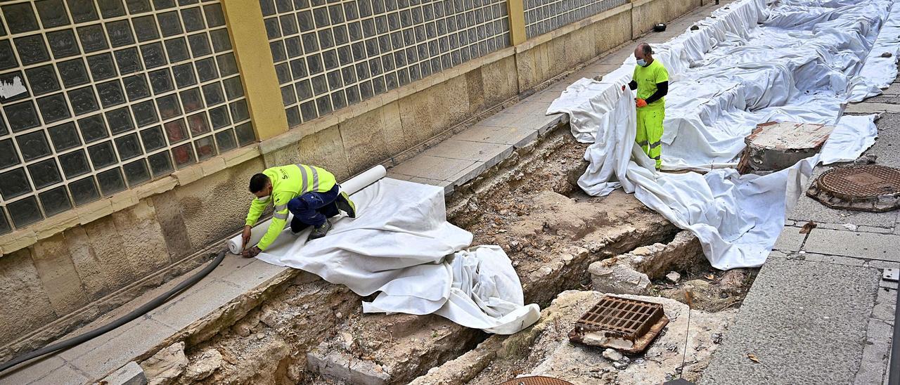 Operarios protegiendo este viernes los restos arqueológicos en el lateral del Mercado ante las inminentes obras. | MATÍAS SEGARRA