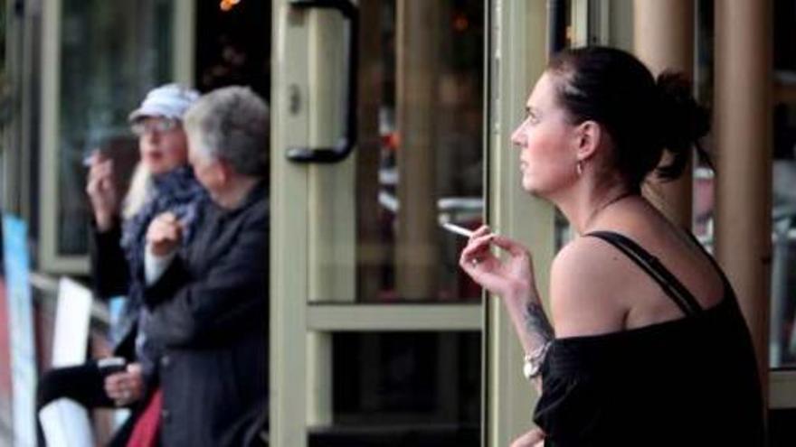 Varios clientes fumando en el exterior de un local de ocio de la primera línea de Levante.