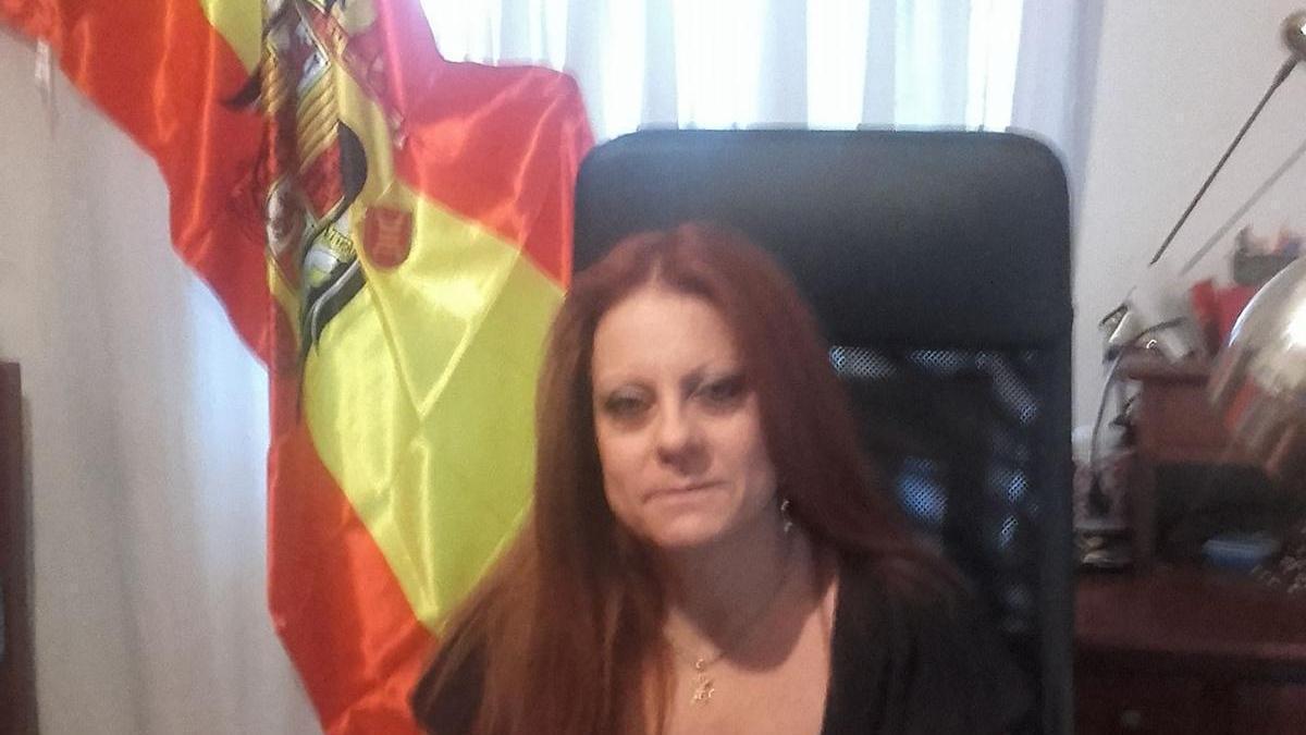 Esmeralda Pastor, recién nombrada directora general de Justicia, posa con una bandera franquista a su espalda.
