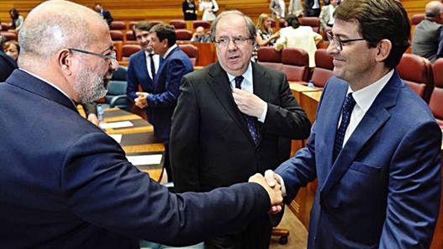 Fernández Mañueco (derecha), recibe la felicitación de su socio de gobierno, Francisco Igea, ante Herrera.