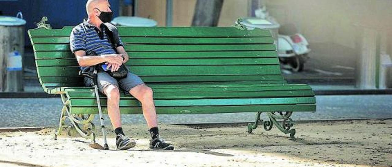 Un hombre descansa en un banco de la capital tinerfeña.