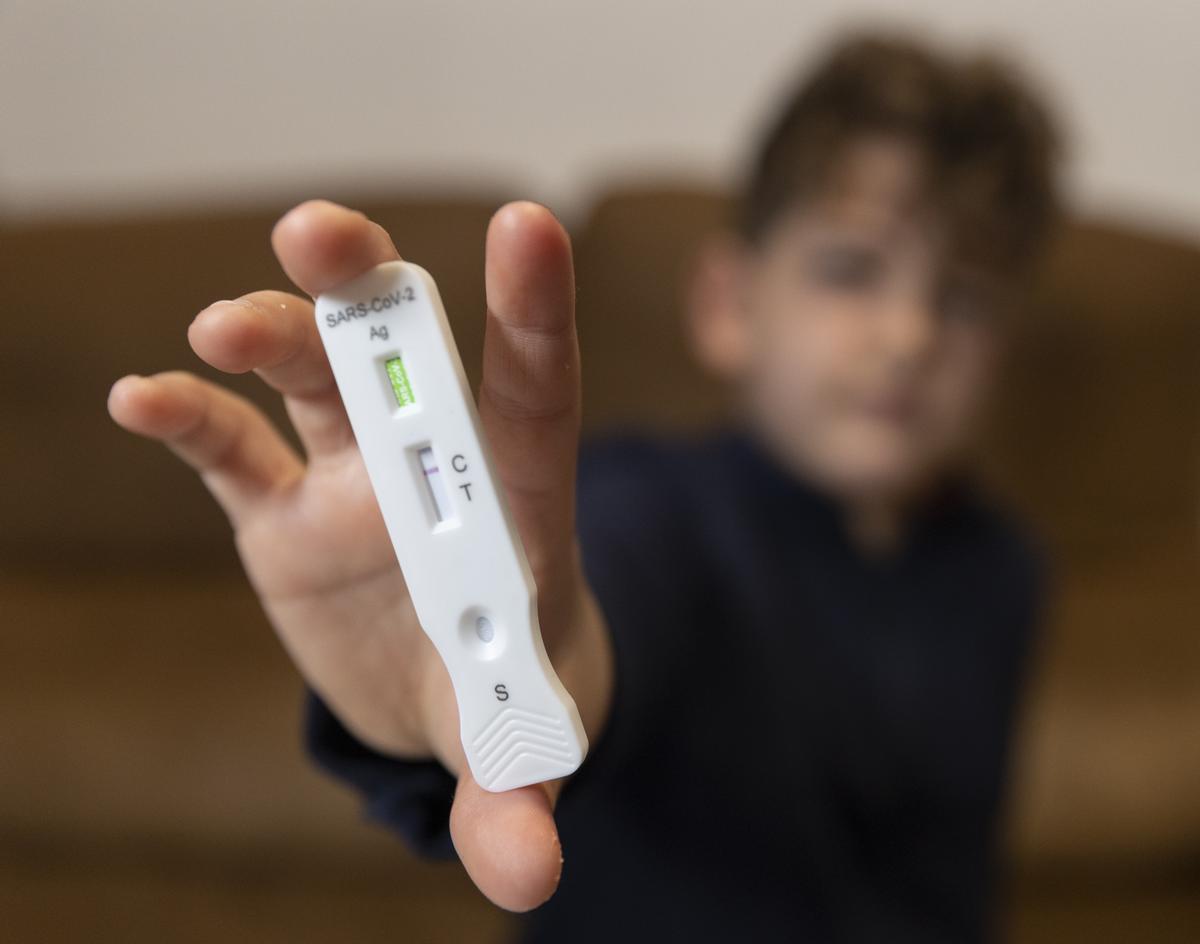 Un niño enseña un test de antígenos (archivo)