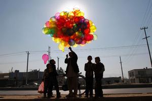 Un home porta globus per vendre’ls a Kabul (Afganistan).