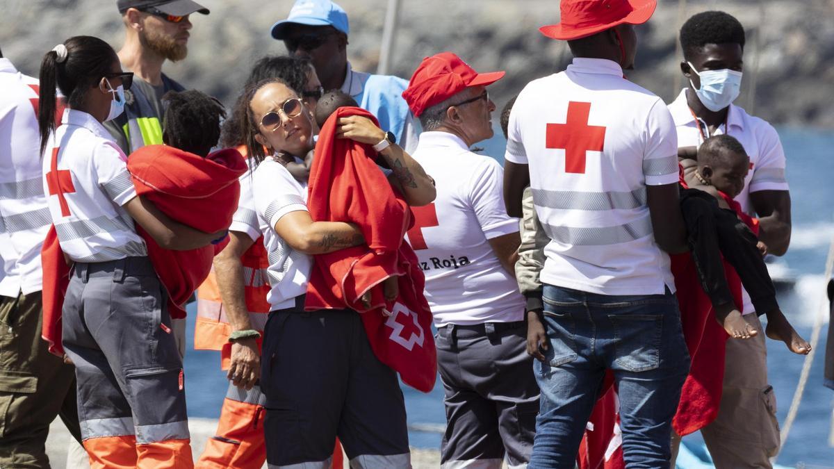 Voluntarios de Cruz Roja atienden a tres niños llegados a Gran Canaria a bordo de un cayuco.