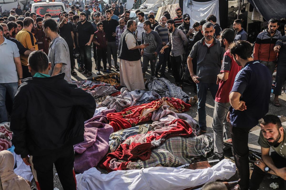 08 de noviembre de 2023, Territorios Palestinos, Ciudad de Gaza: Los palestinos inspeccionan los cuerpos de las víctimas que murieron en los bombardeos israelíes mientras yacen fuera del hospital Al-Shifa, en medio de las batallas en curso entre Israel y el grupo palestino Hamas.
