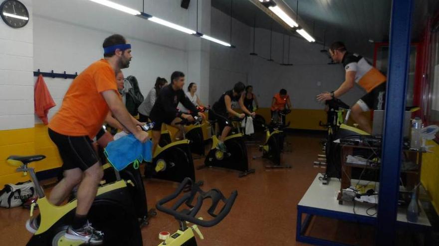 Alumnos en una clase de bicicleta indoor, en el polideportivo.