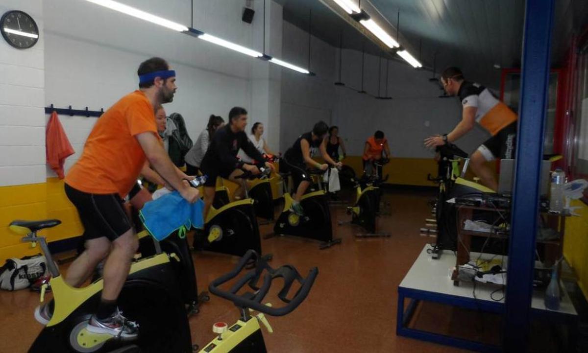 Alumnos en una clase de bicicleta indoor, en el polideportivo.