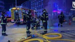 Bomberos trabajan en las labores para extinguir un incendio en Callao, Madrid