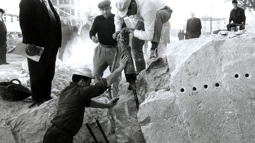 Alzira 1966. El desarrollismo de los años sesenta transformó el perfil de muchas ciudades. Alzira apostó por derribar el histórico Pont de Sant Bernat, cuyos orígenes se remontan al siglo XIII, para levantar una pujante avenida llena de grandes edificios. Del puente solo quedan en pie los casilicios y una parte del pretil reconstruido recientemente.