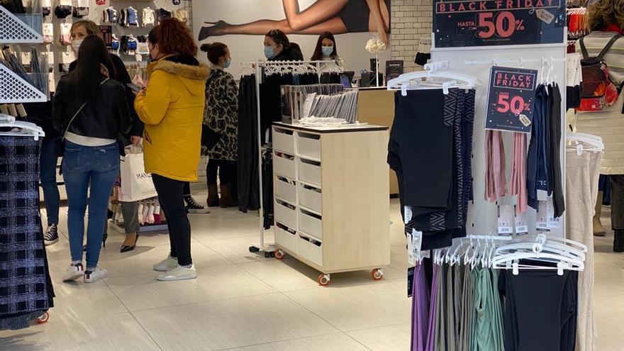 Clientas en una tienda de ropa que ofrece descuentos por el Black Friday