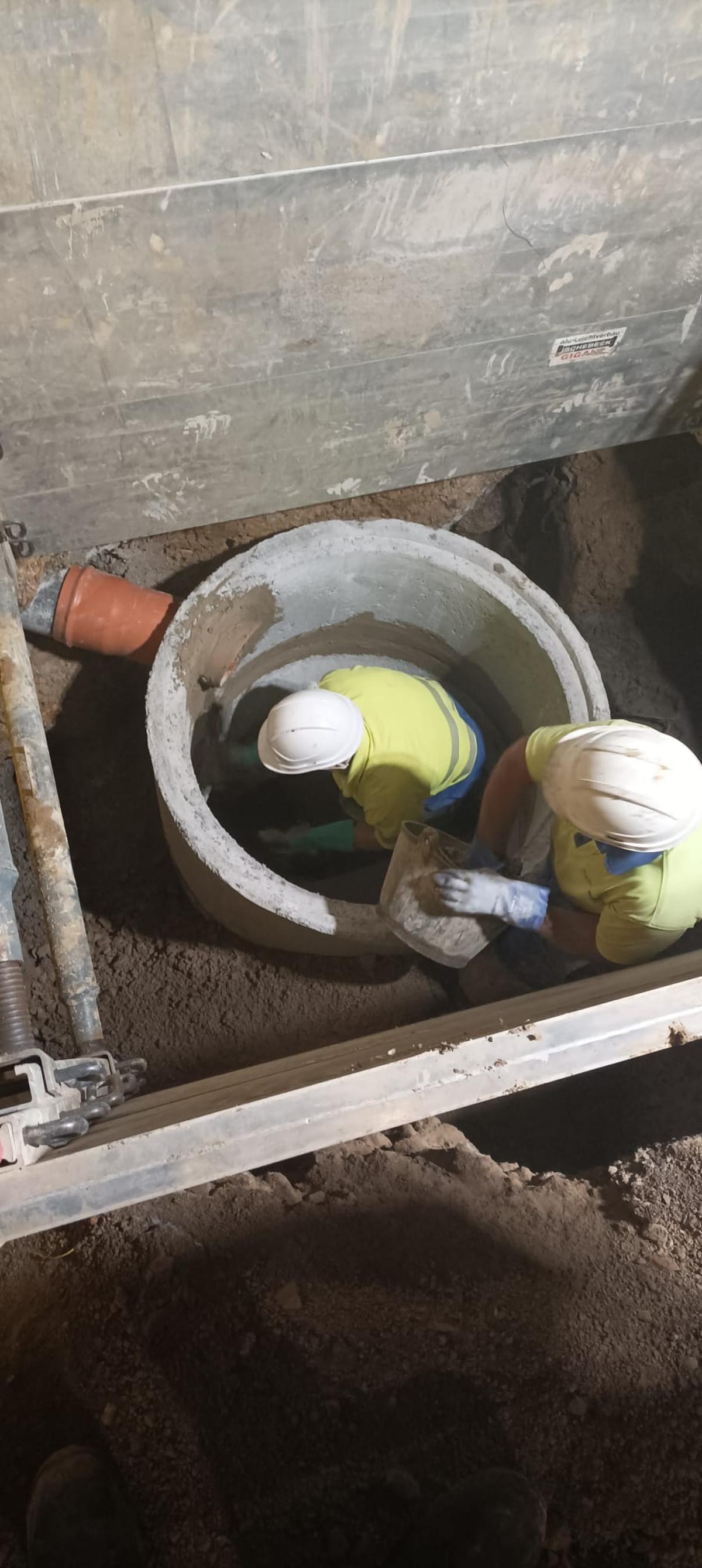 Dos operarios de la EMA durante la reparación de la red de saneamiento, en El Coto.