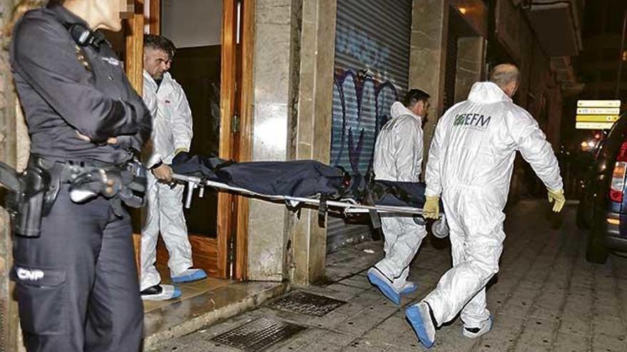 Empleados de los servicios funerarios trasladan uno de los cadáveres hallados ayer tarde en un piso de la calle Gabriel Maura.