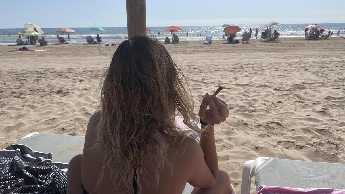 Una de las bañistas en la playa de la Patacona fumando.