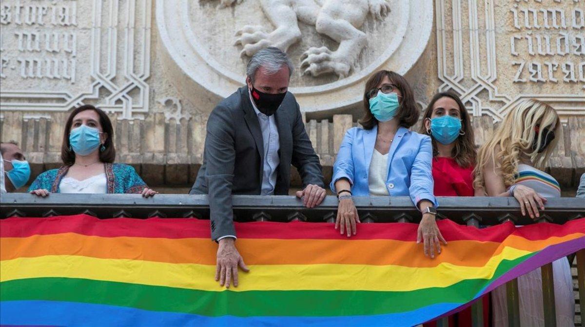 El alcalde de Zaragoza, Jorge Azcón, coloca la bandera LGTB en el ayuntamiento, acompañado por miembros del consistorio.