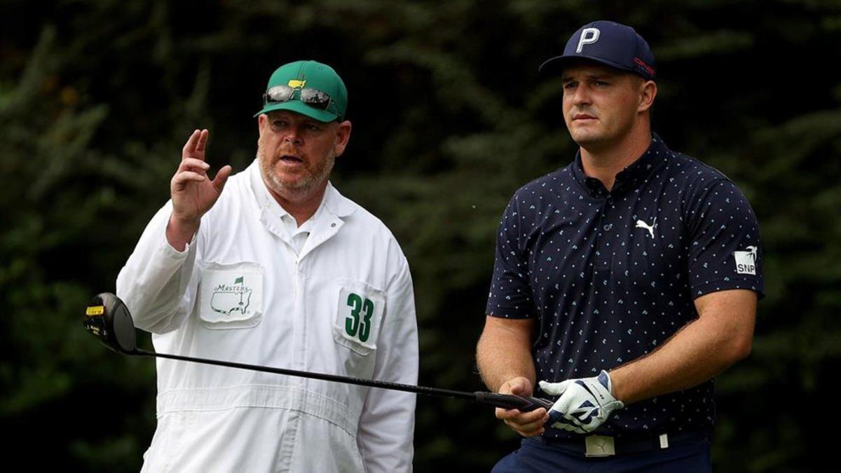 De Chambeau charla con su caddie antes de ejecutar un golpe en la vuelta de prácticas