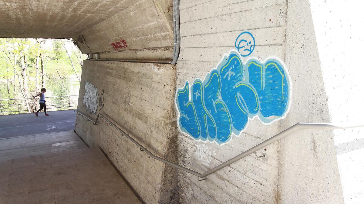 Varias pintadas en el paso subterráneo hacia el paseo fluvial.