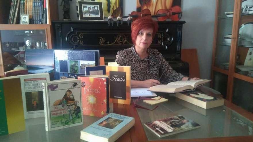 María José Ortiz, bibliotecaria de El Entrego, con varios libros.