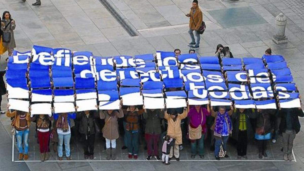 Unas mujeres forman un mural reivindicativo, la víspera del Día contra la Violencia de Género del 2011, en Madrid.