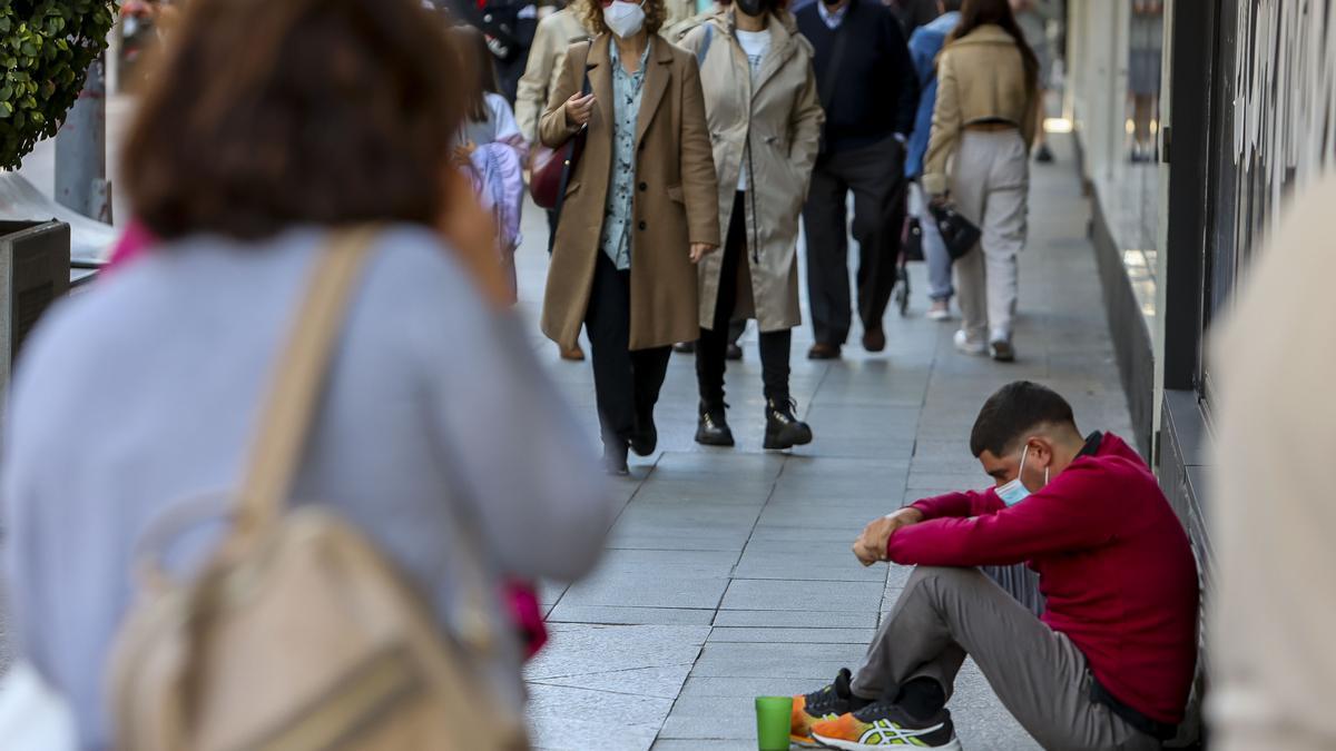 Un joven pide en una de las calles más céntricas de la ciudad