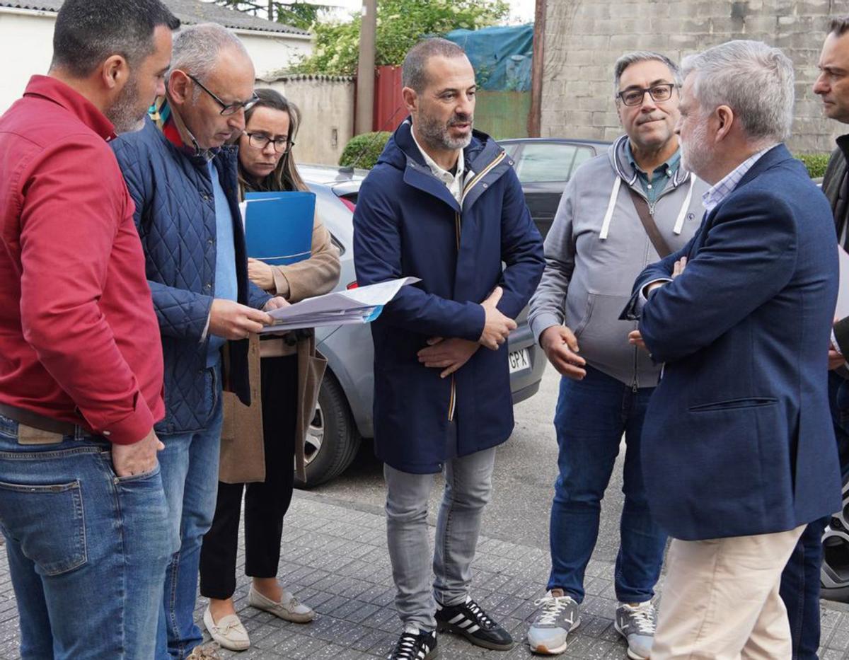 Por arriba, el alcalde sierense,Ángel García, tercero por la izquierda, con el equipo de Comercial Pocholo, con motivo de su 25º anivesario este año; el regidor durante una reunión con empresarios del área empresarial de La Meana, en La Carrera, donde el Ayuntamiento llevará el saneamiento; y vista del polígono de Bobes.| Cedidas a Lne