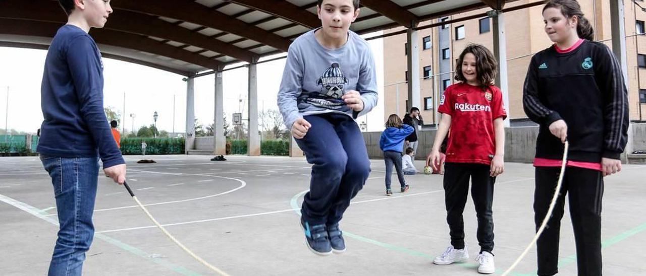 De izquierda a derecha, Marcos Suárez, Pelayo Romay, Nora San José y Paula Romay, jugando a la comba ayer, en la cancha polideportiva del colegio Ángel González.