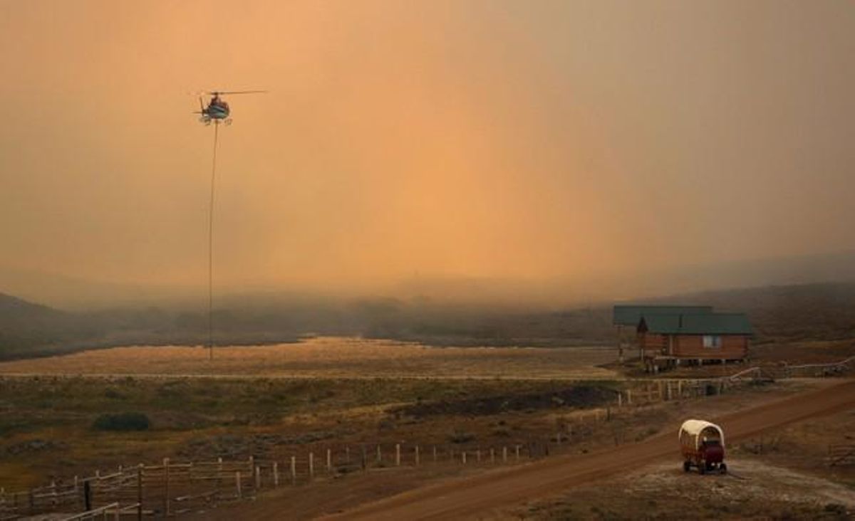 Un helicóptero recoge agua para apagar un gran incendio en Wyoming.