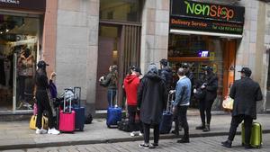 Turistas aguardan en la entrada de su alojamiento en la calle Ferran de Barcelona. 