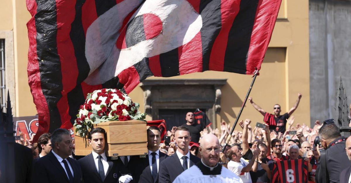 El féretro entra en el templo bajo una gigantesca bandera con el 6.