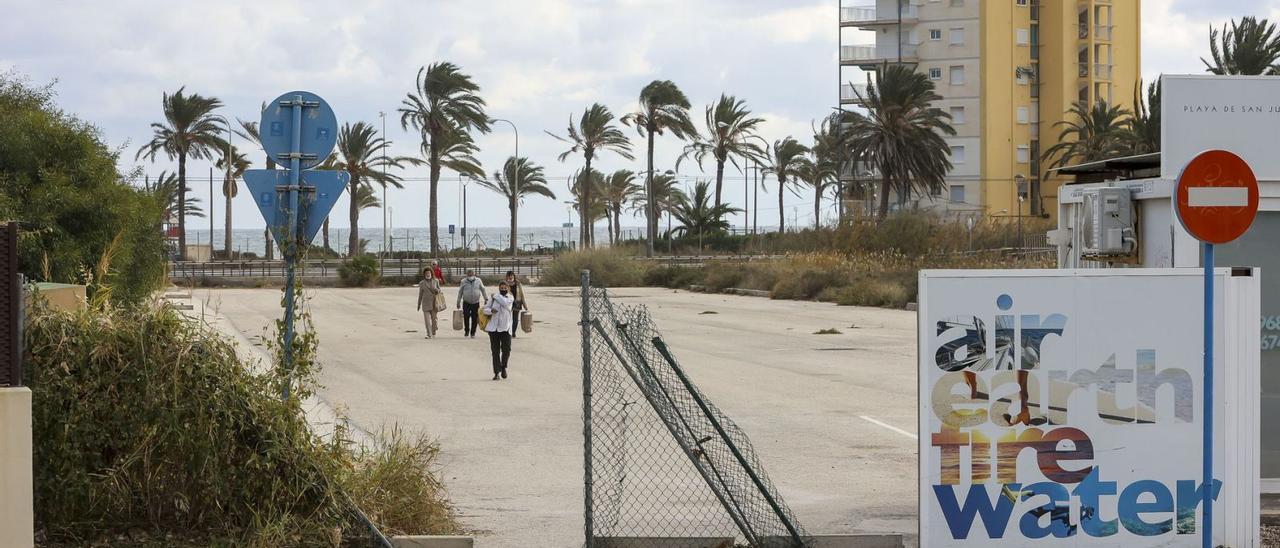 Varias personas cruzan por una parcela privada hacia el PAU 5. Los vecinos llevan años pidiendo la conexión peatonal con la avenida de Niza. | HÉCTOR FUENTES