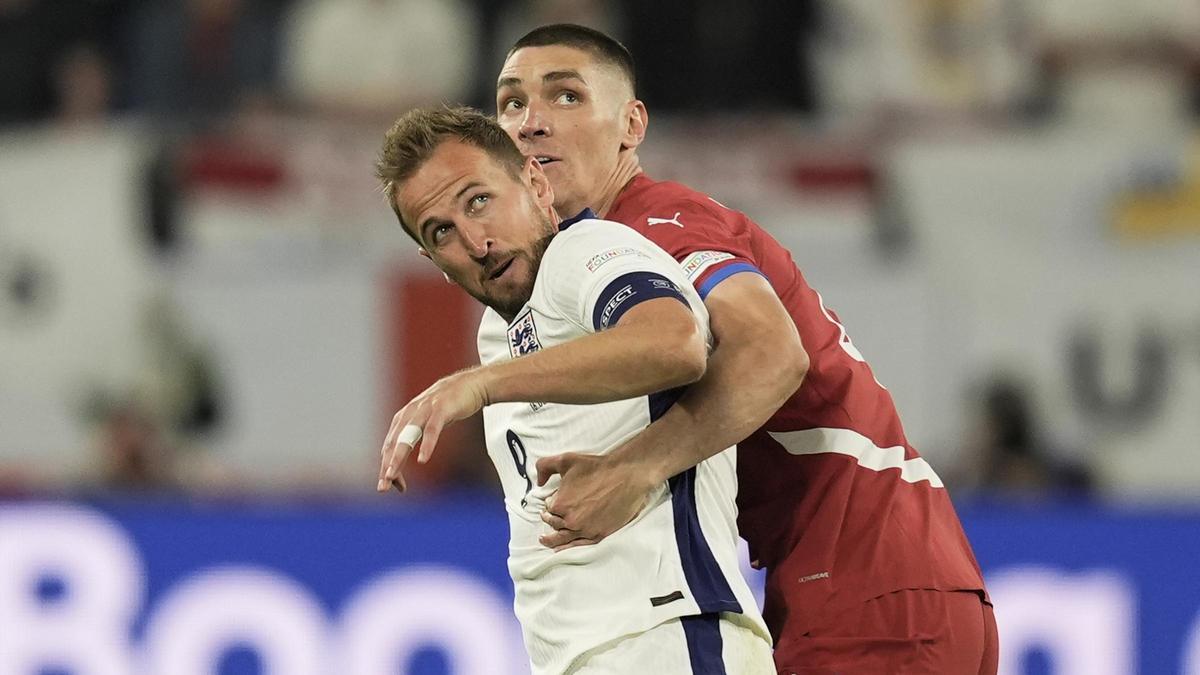 Kane y Milenkovic abrazos, esperan un balón con la mirada.