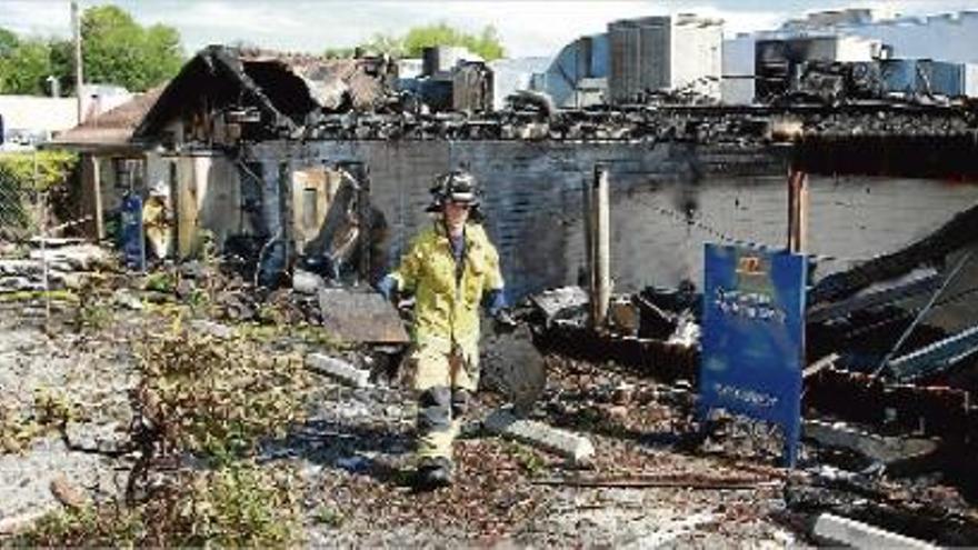 Un bomber retirant material de l&#039;edifici del restaurant Manresa de Los Gatos, ahir un cop controlat l&#039;incendi