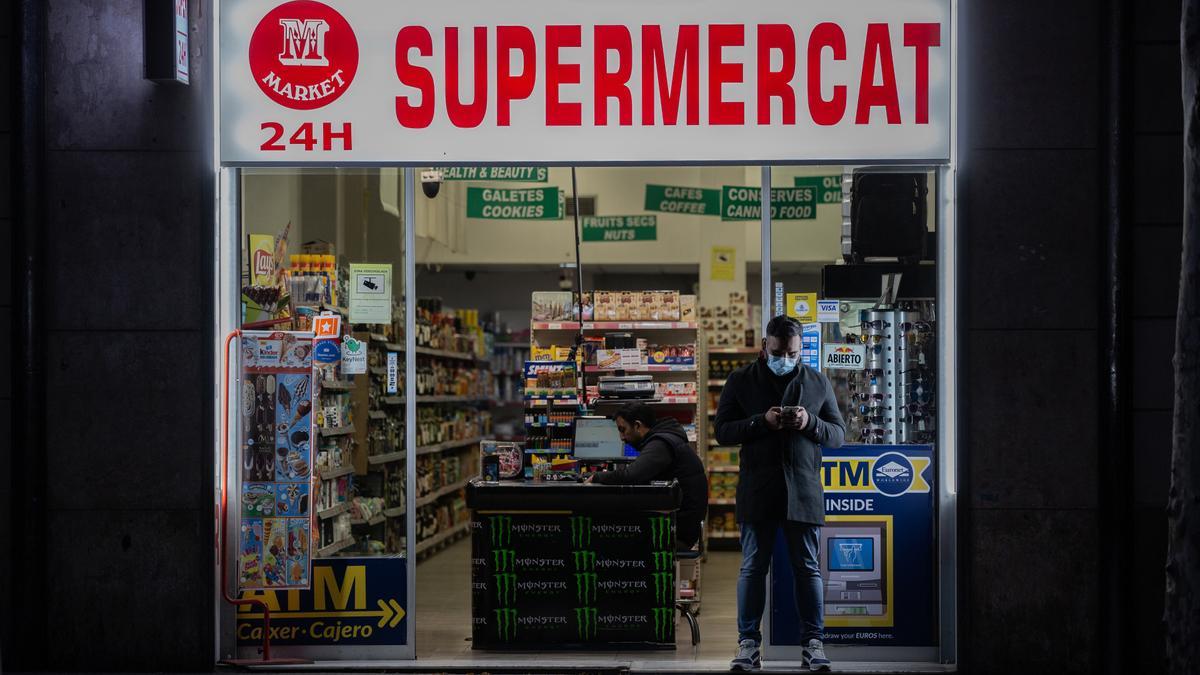 Archivo - Un hombre protegido con una mascarilla en la puerta de un supermercado 24 horas abierto, en Barcelona/Catalunya (España) a 23 de marzo de 2020.