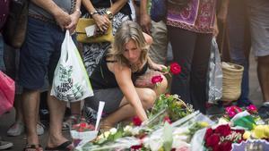 Una joven deposita una ramo de flores en el mosaico de Miró. JORDI COTRINA