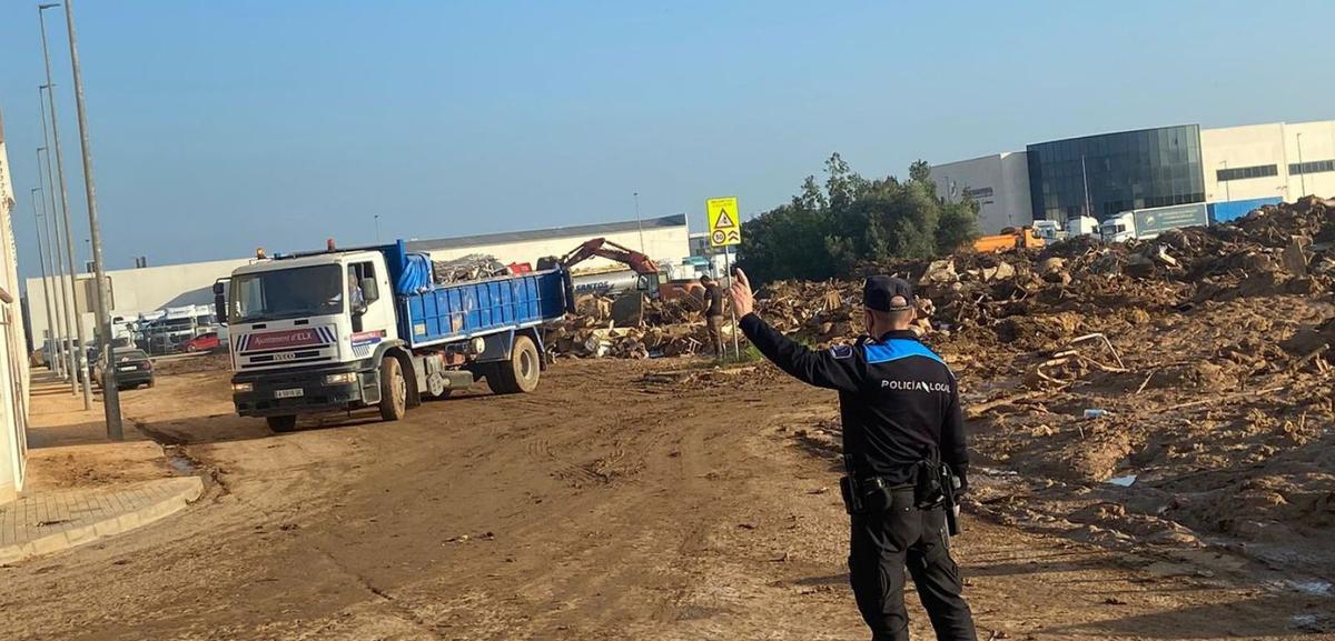 Policías de Cangas ayudando en el depósito de lodos y escombros. |  FdV