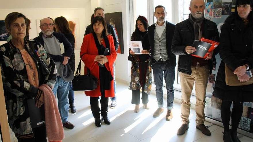 Un grupo de asistentes a la inauguración de la exposición de arte.