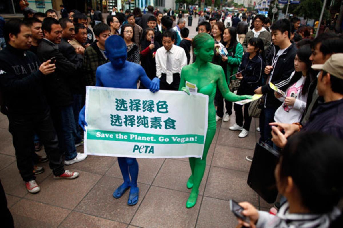 Dos membres de l’associació que defensa el tracte ètic dels animals, PETA, es pinten de blau i verd per captar l’atenció dels vianants en un carrer del centre de Xangai (Xina).