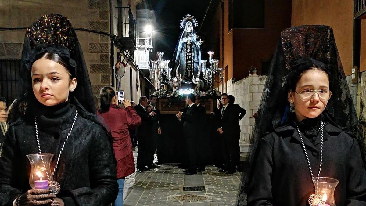 Dos jóvenes toresanas arropan a la Virgen de los Dolores y alumbran la procesión con sus tulipas y velas. | M. J. C.